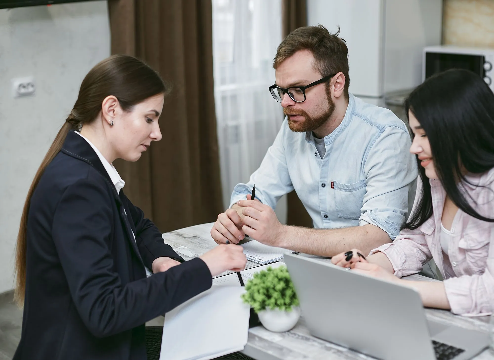 Three colleagues reviewing documents together at a table.